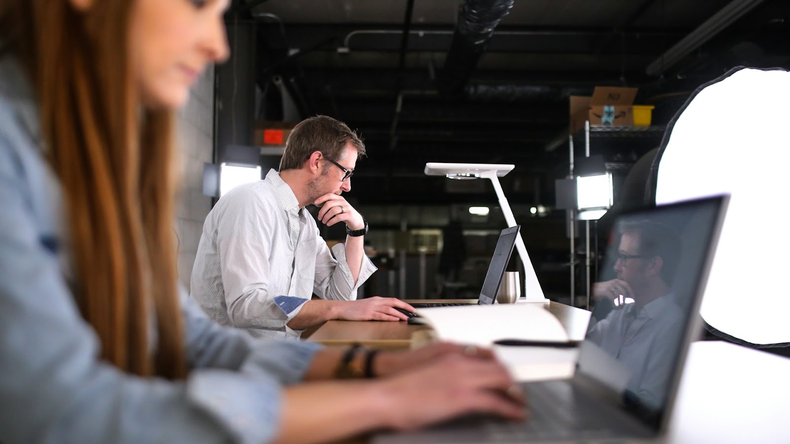 absentéisme au travail, deux personnes travaillent sur leurs ordinateurs