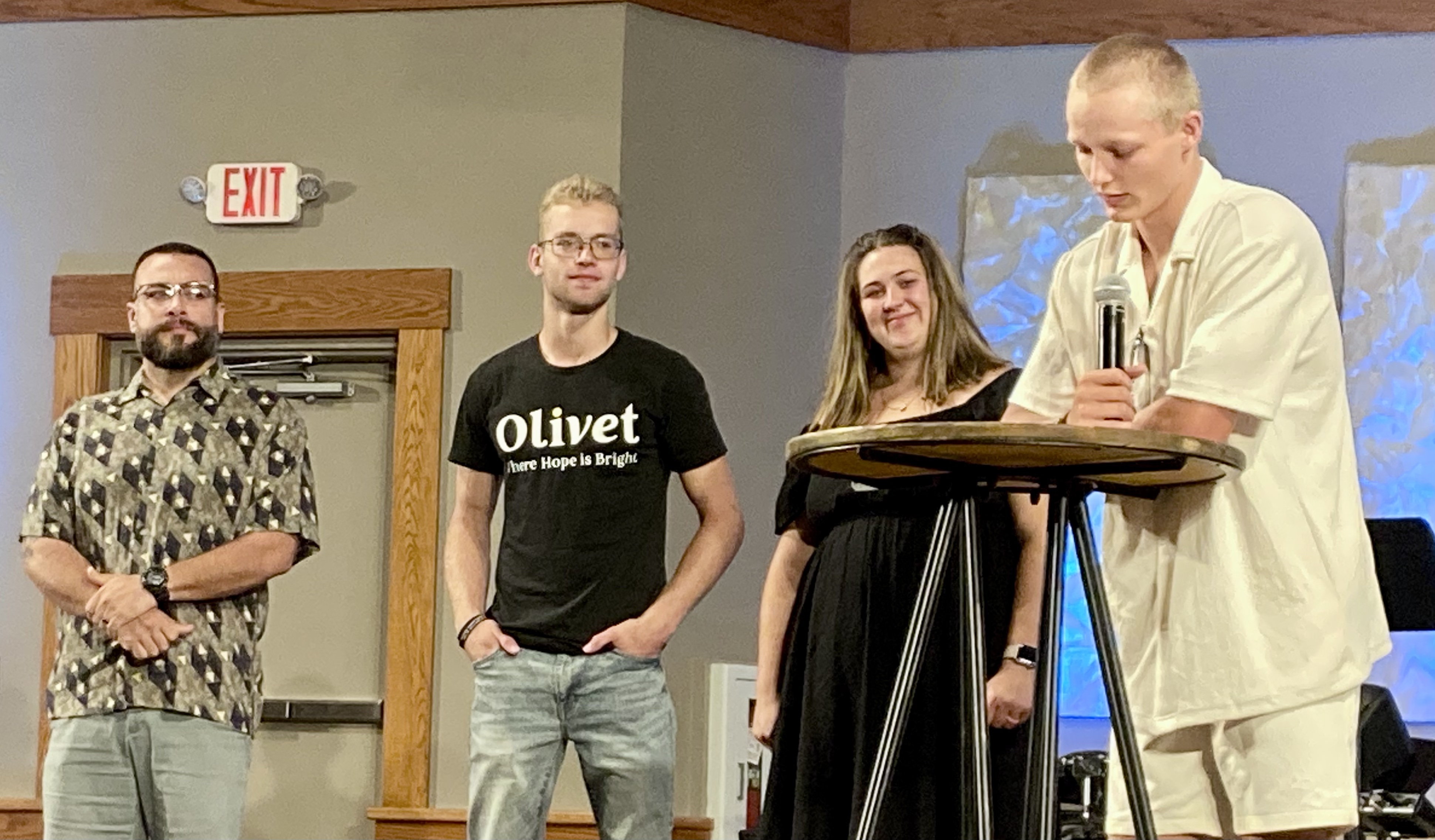 Smiling woman holding young boy while talking to other woman