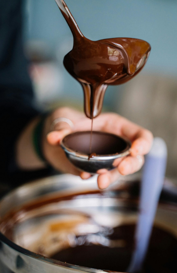 Un personne est en train de réaliser un oeuf en chocolat