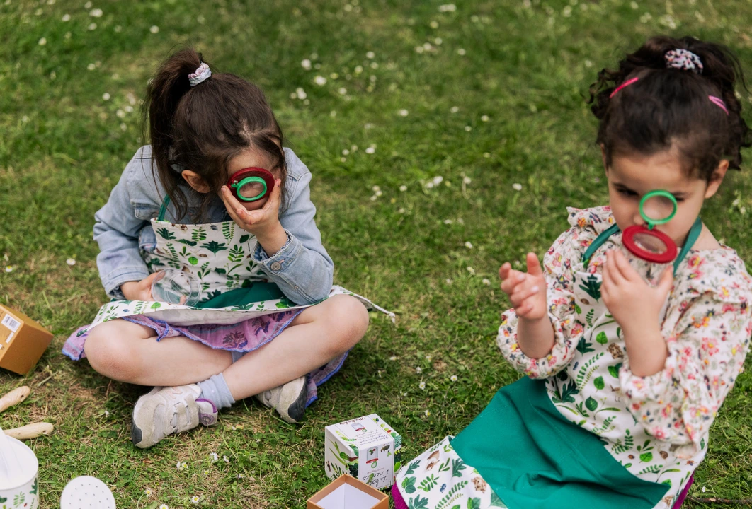 Des enfants jouent au petits jardiniers dans l'herbe