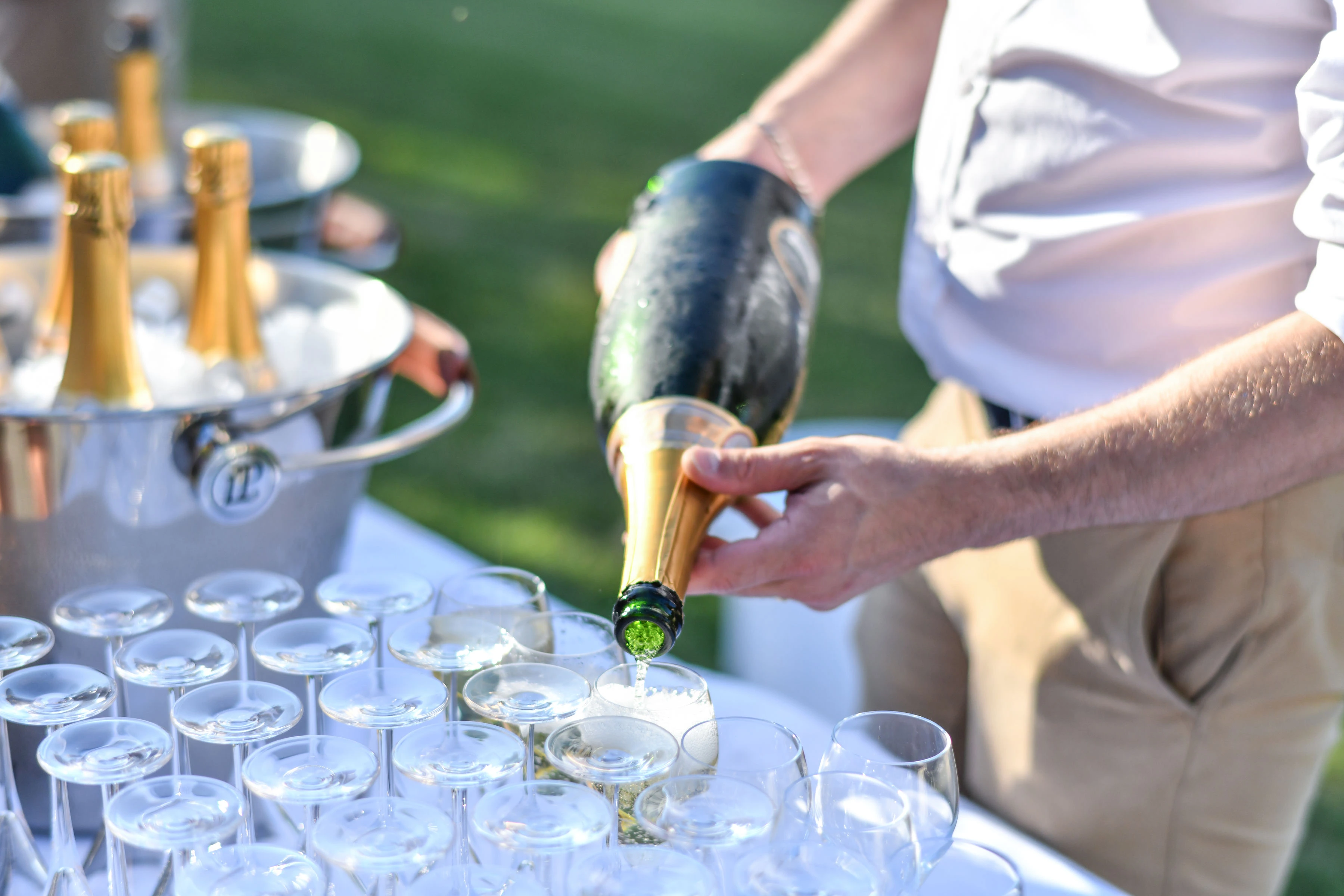 Bottles of champagne and soft drinks are arranged on a table decorated with flowers