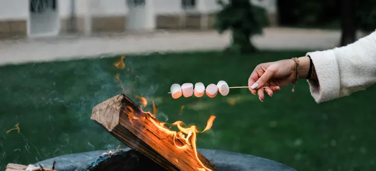 Une femme fait griller des chamallow au braséro