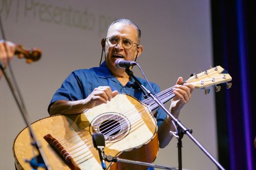 A close-up photo of a man, Juan Morales, playing guitar.