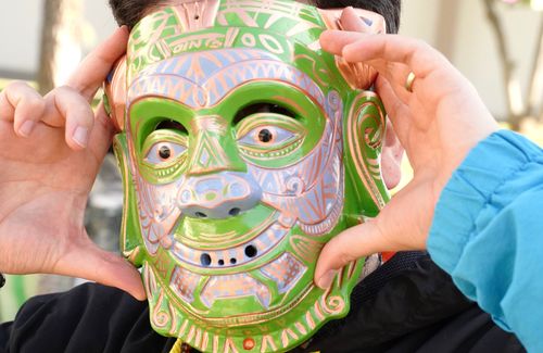 A close-up of Gabriel Gutierrez's face, covered fully by his patterned, green and purple mask.