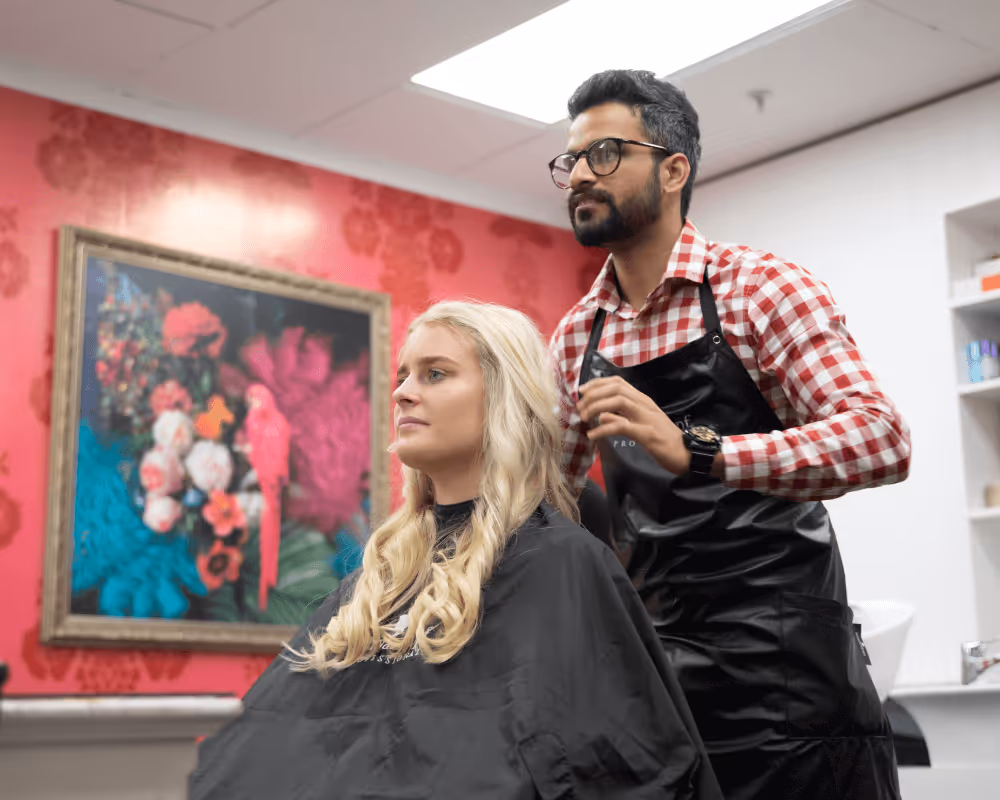 A male hairdresser styling a customers hair