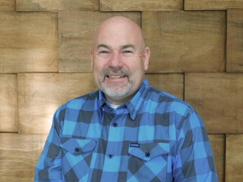 A smiling white man with facial hair