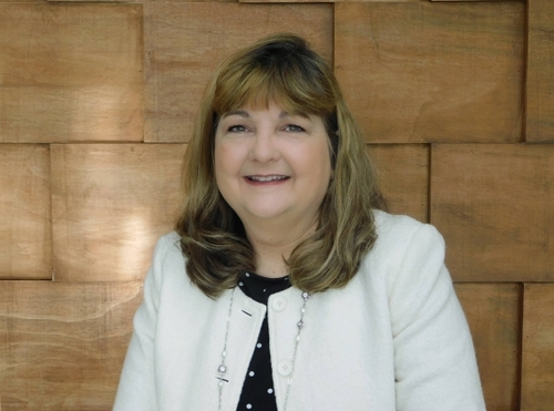 A smiling white woman with curled hair