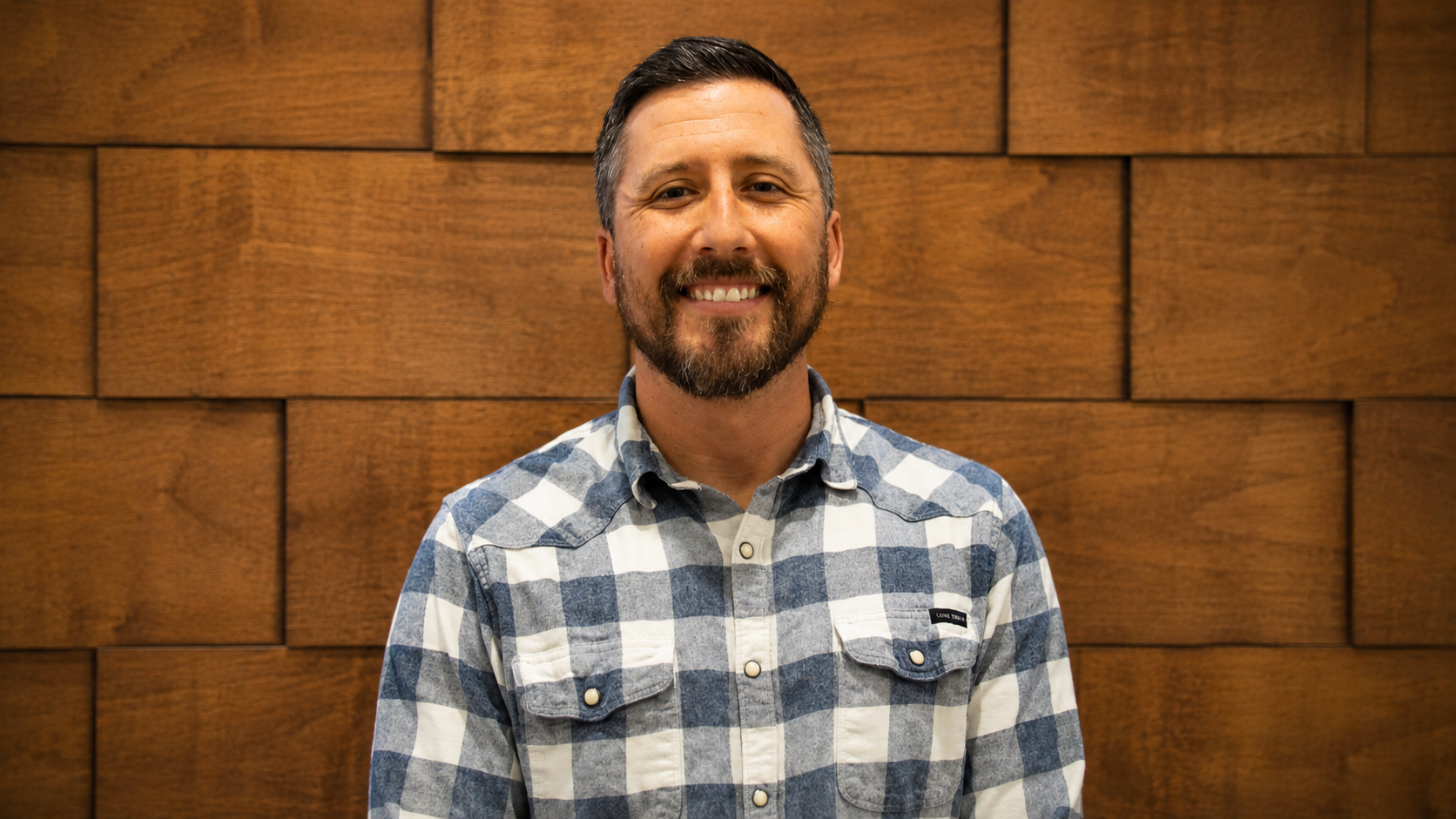 smiling white man in a plaid shirt