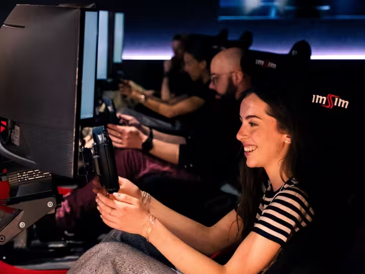 A guest laughing while driving an ImSim simulator for the first time.