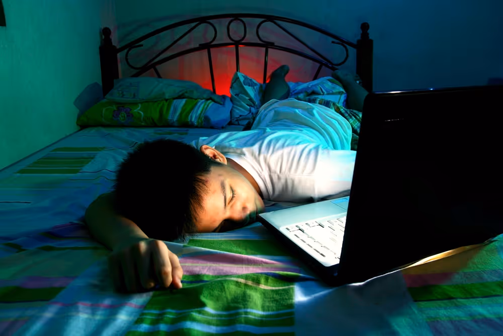 Young man lying down with laptop