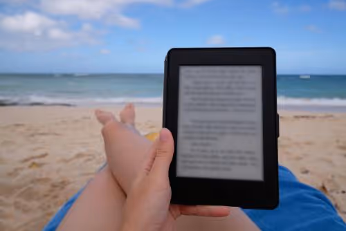 lady using kindle on the beach