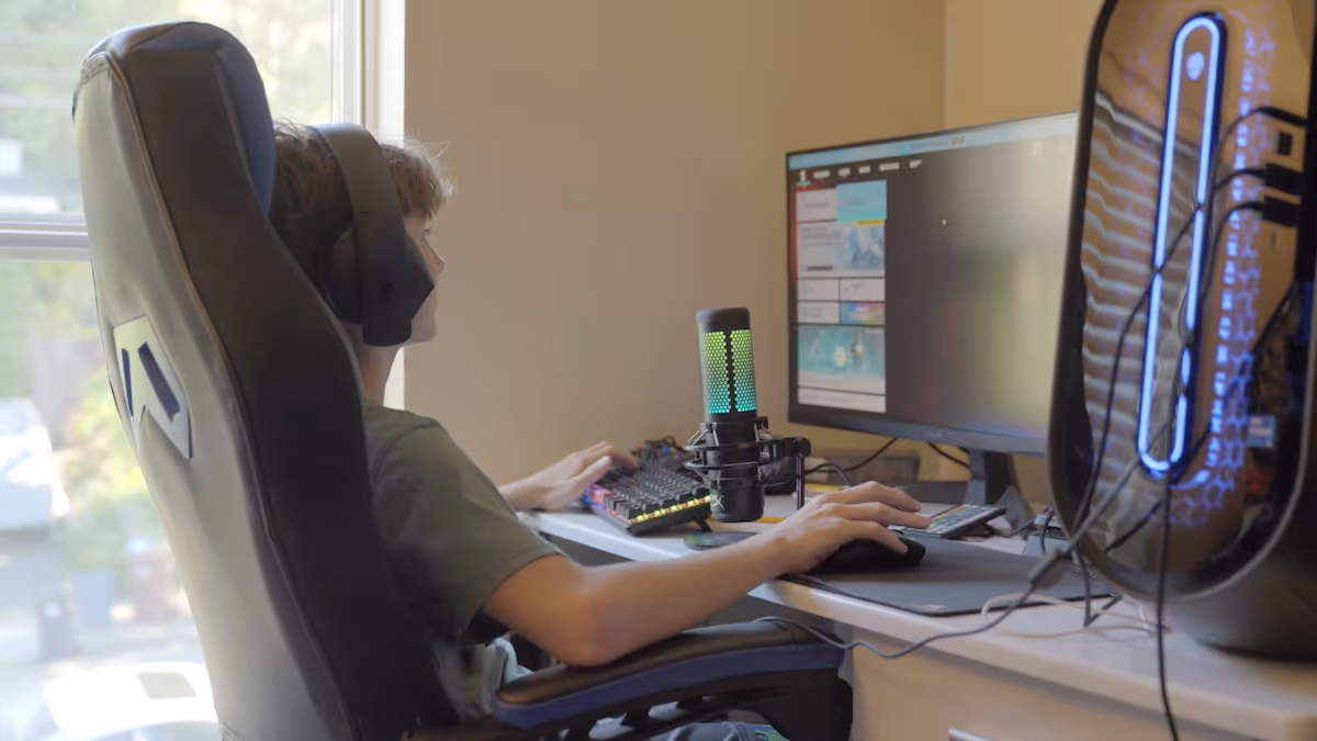 Teen boy sat at computer desk about to play a game of fortnite