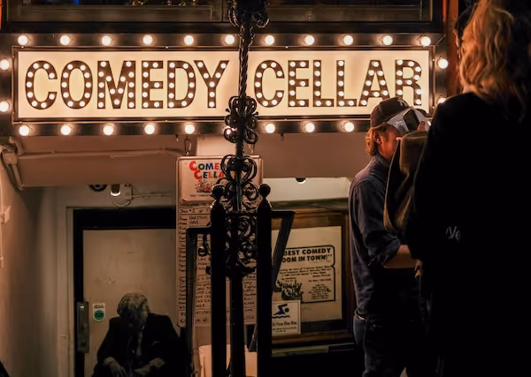 Entrance to a comedy club with the name "Comedy Cellar" lit up above the door.