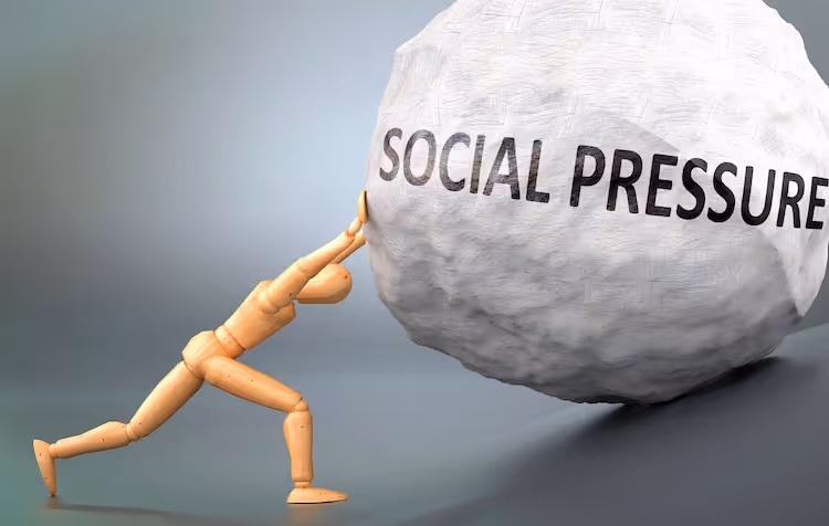 Stick figure pushing a rock with social pressure on it