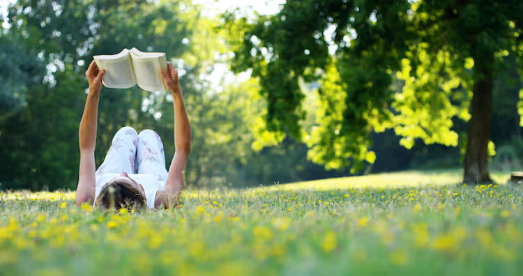 Girl reading book in a park