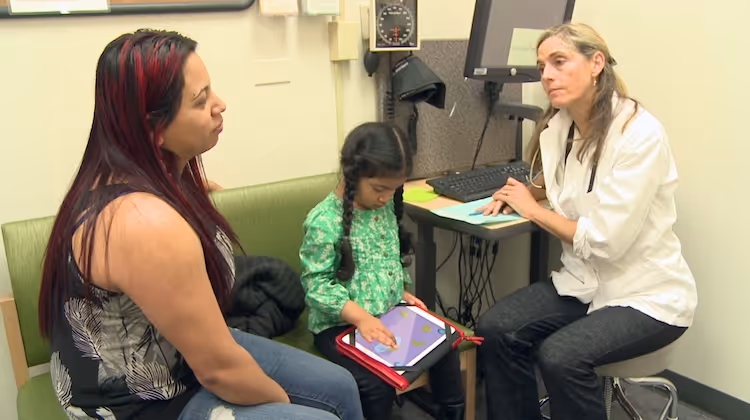 2 ladies and a child playing with her tablet