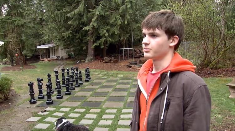 Teenage boy with chess in the background
