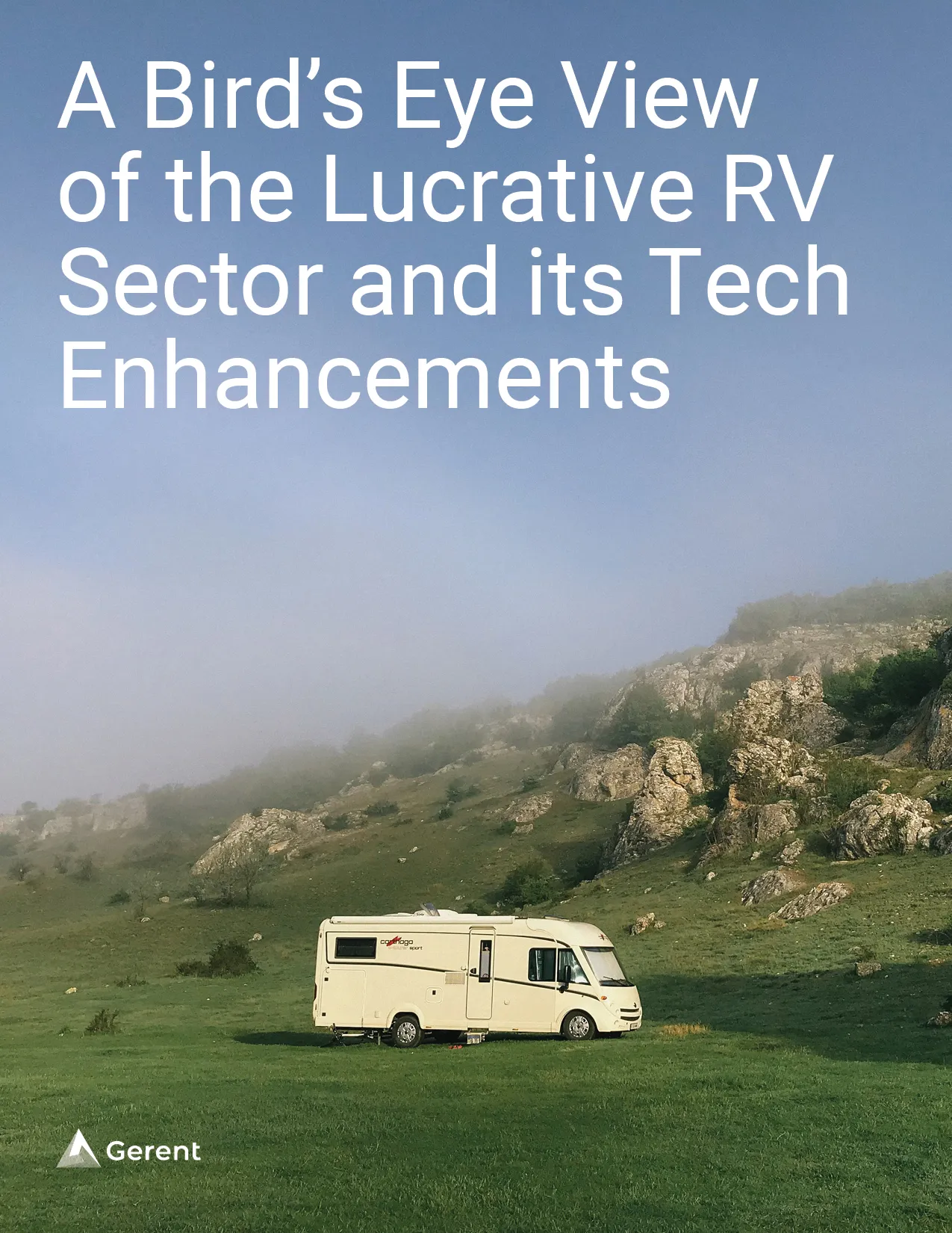 An RV parked in a green field with big rocks 