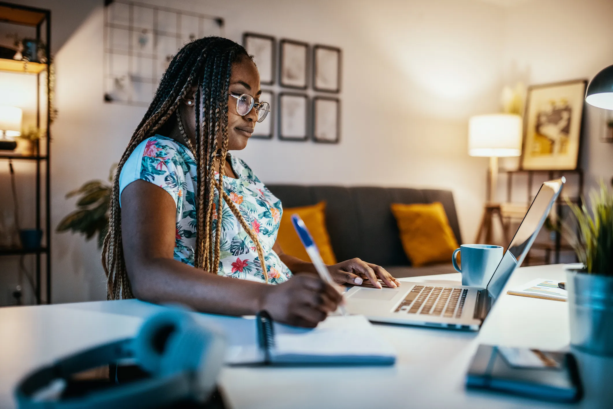 African American Female Student Studying From Home and Taking Notes from Professor