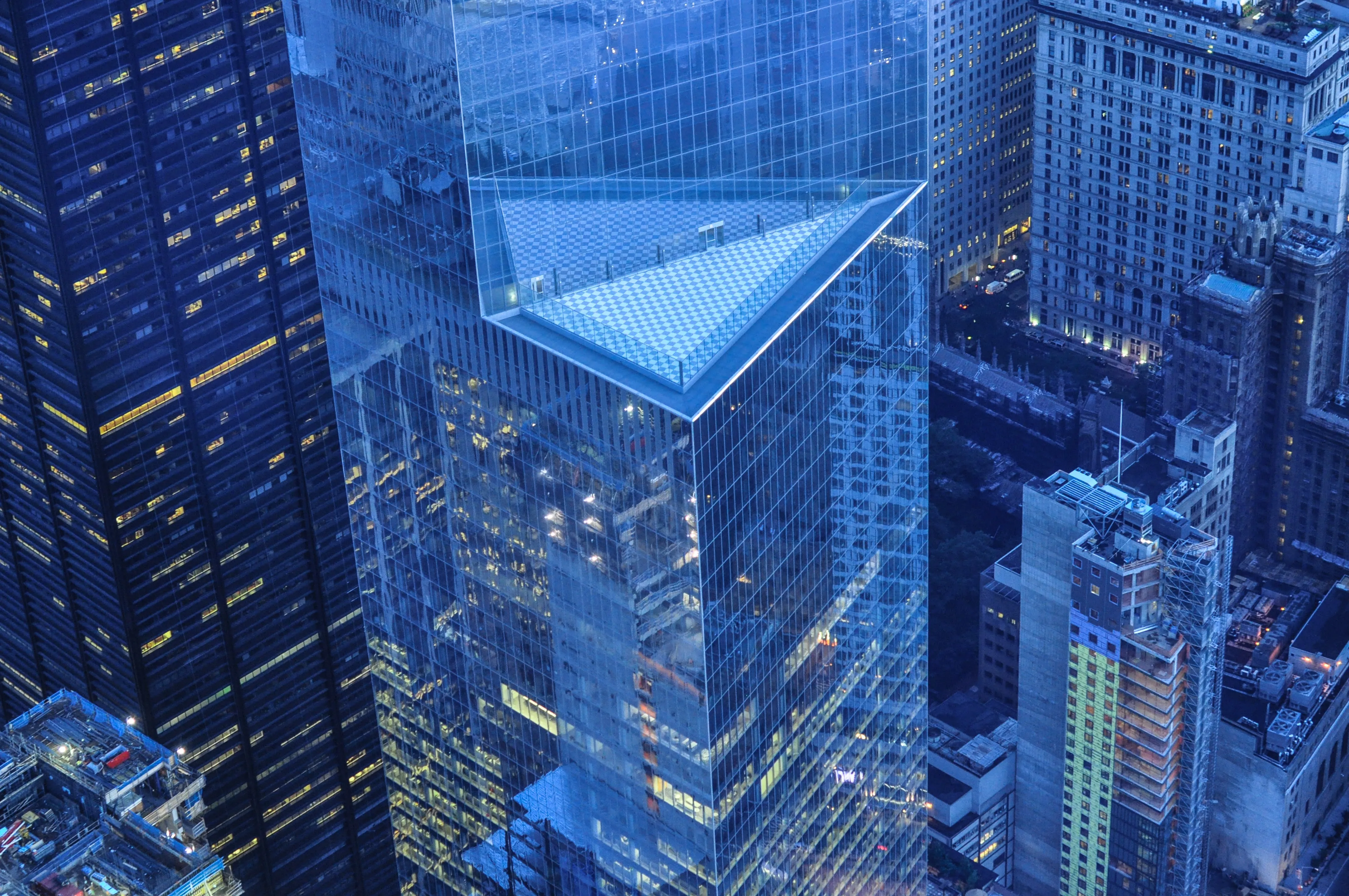 A picture of tall, glass skyscraper city buildings. they look dark blue.