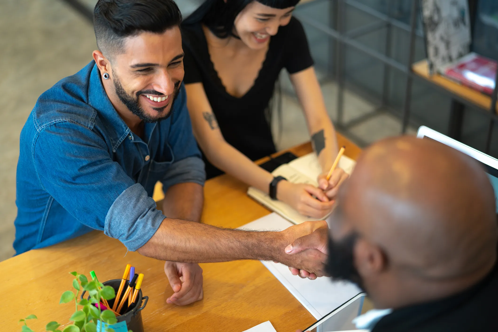 two insurance customers shaking hands of insurance sales person
