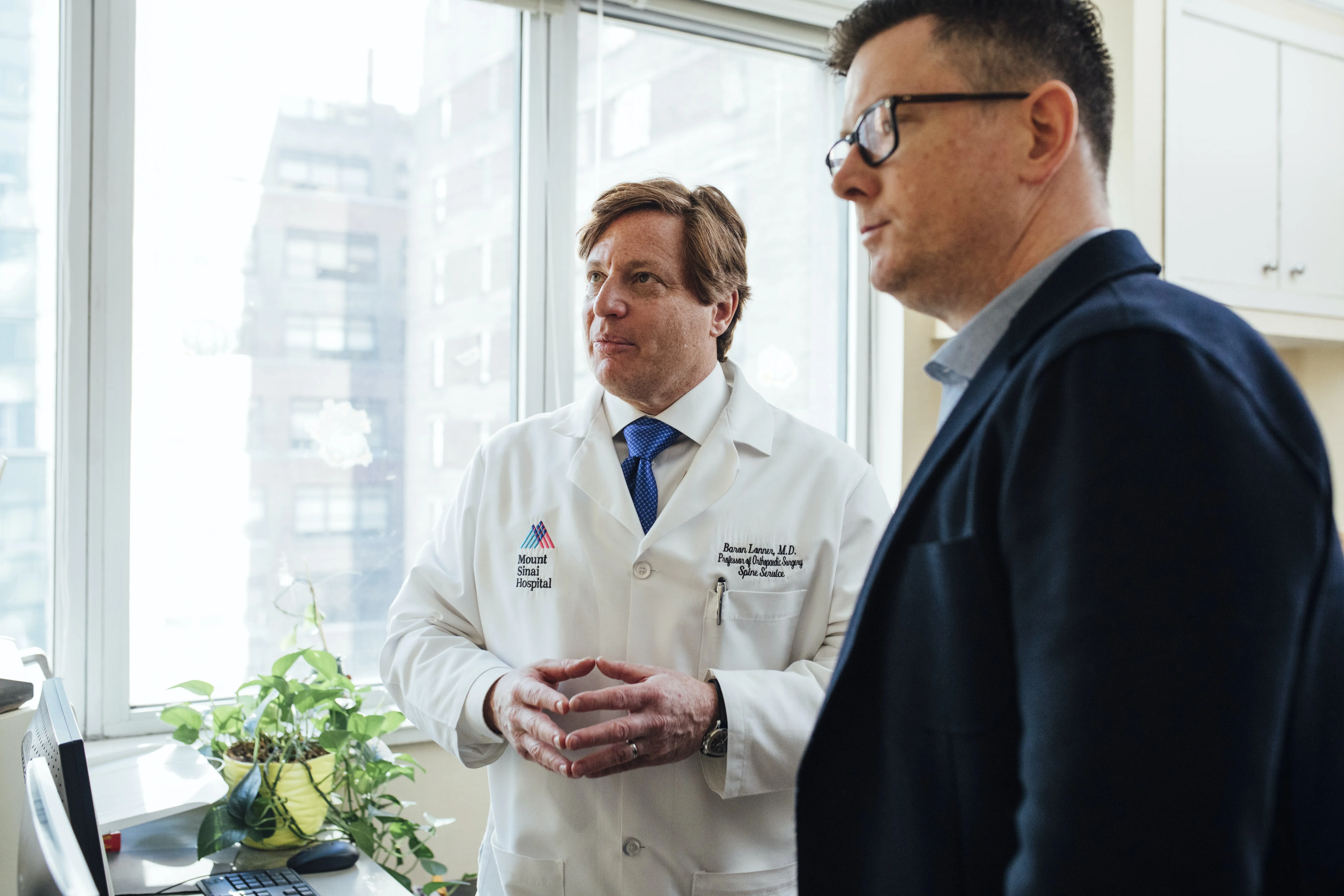 Doctor and insurance rep standing in hospital