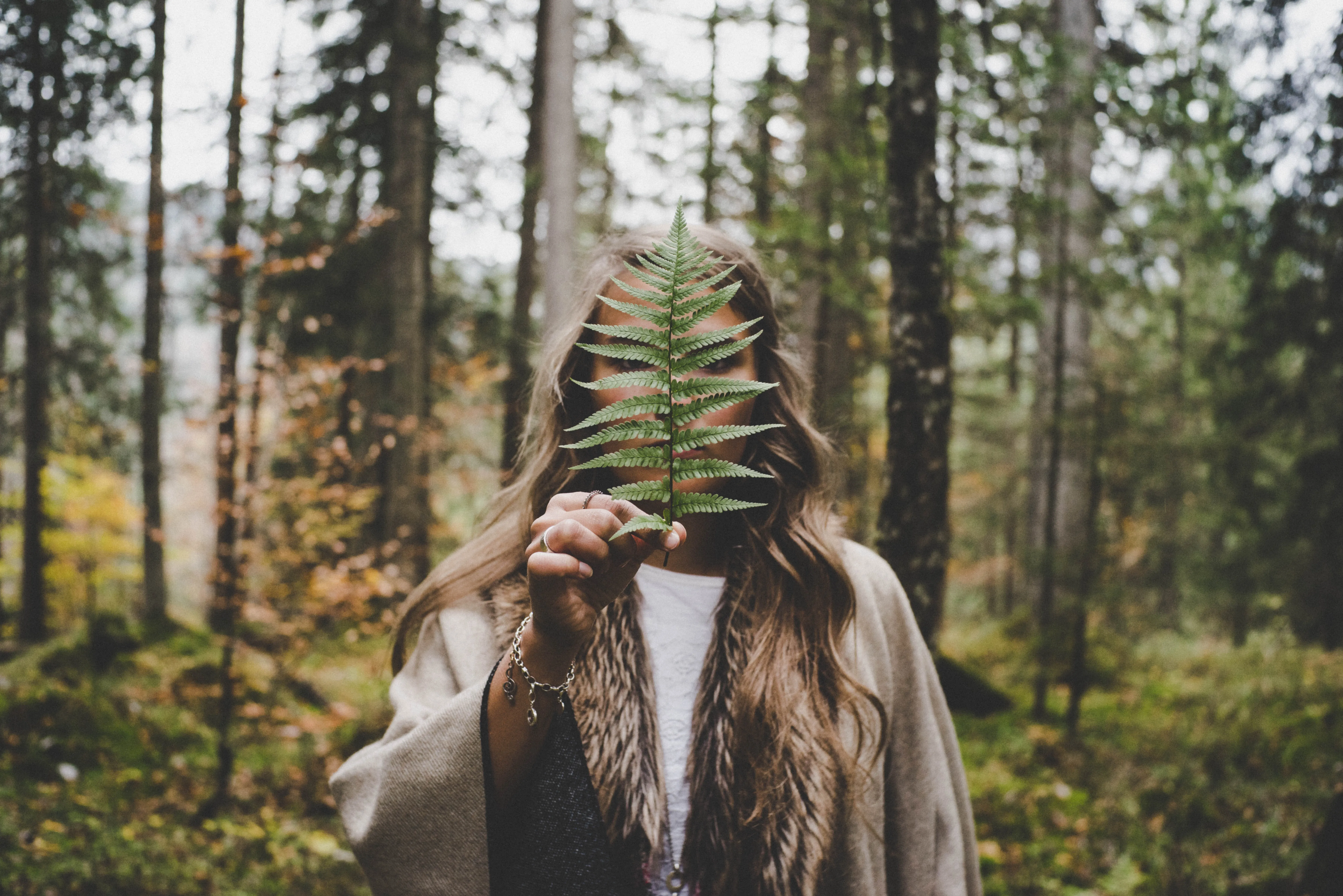 Woman holding a leaf in the woods