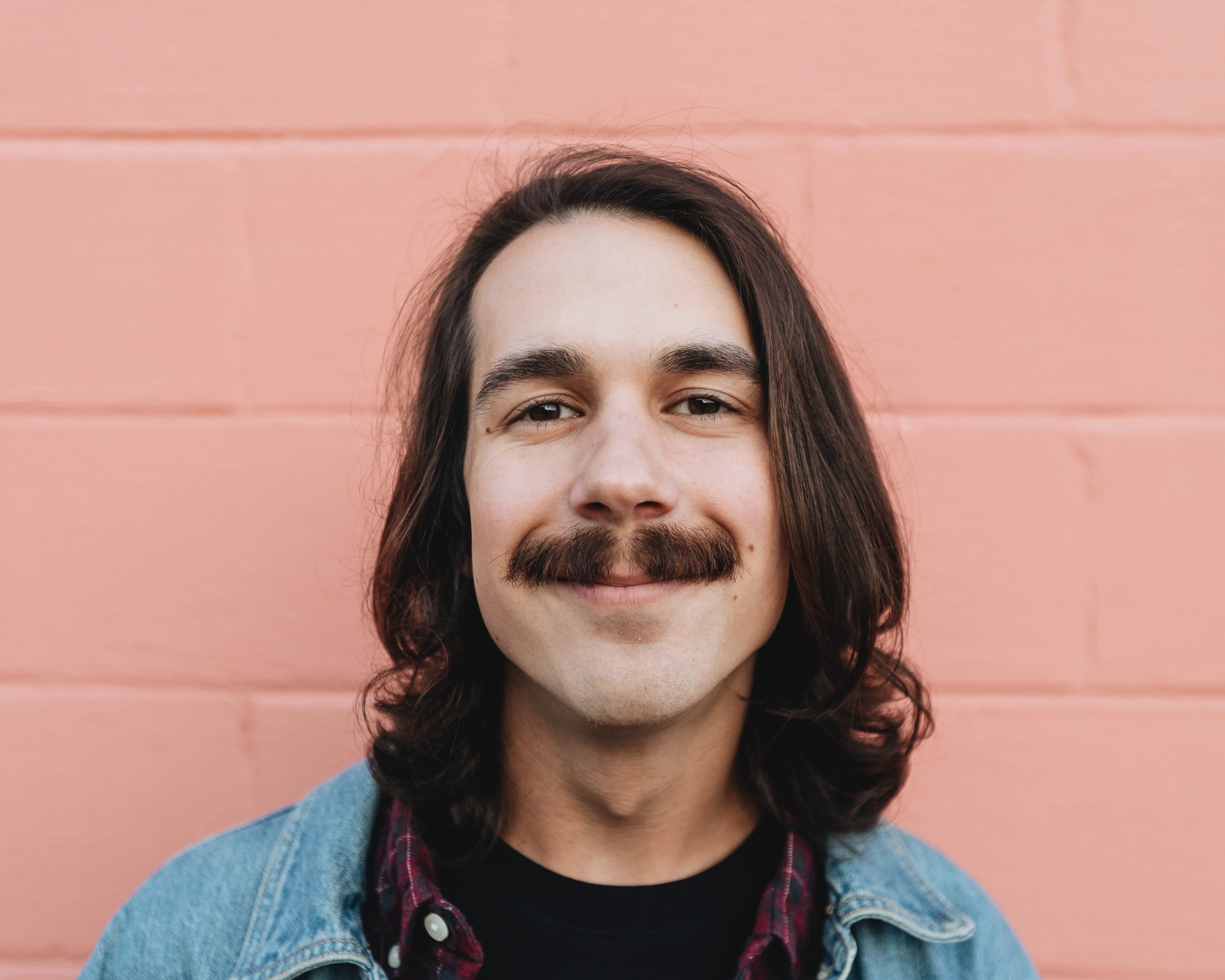 Long haired man with mustache smiling