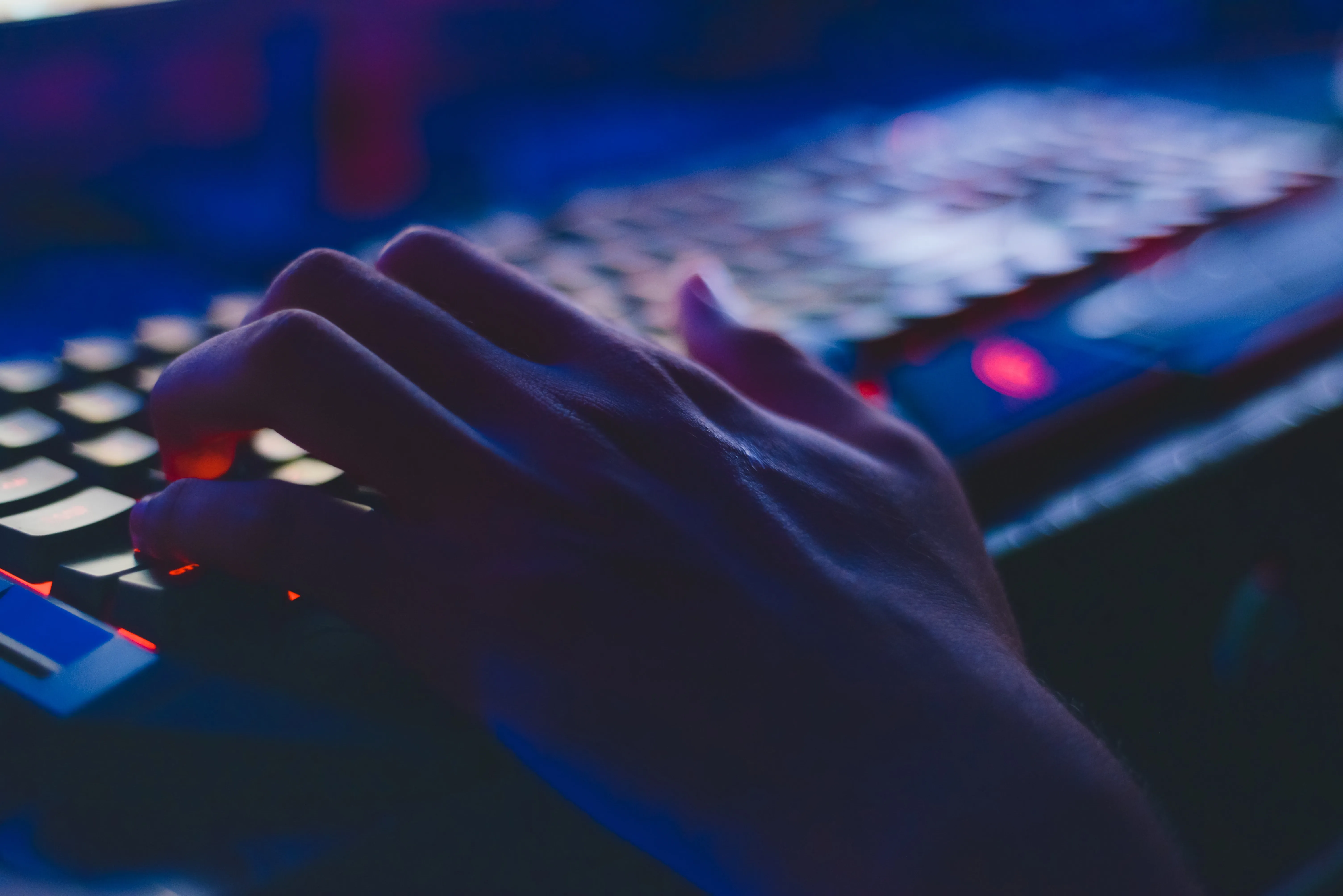 Person typing on their keyboard in the dark