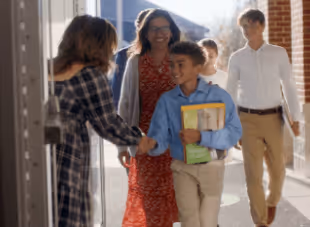 A boy shaking hands with a teacher