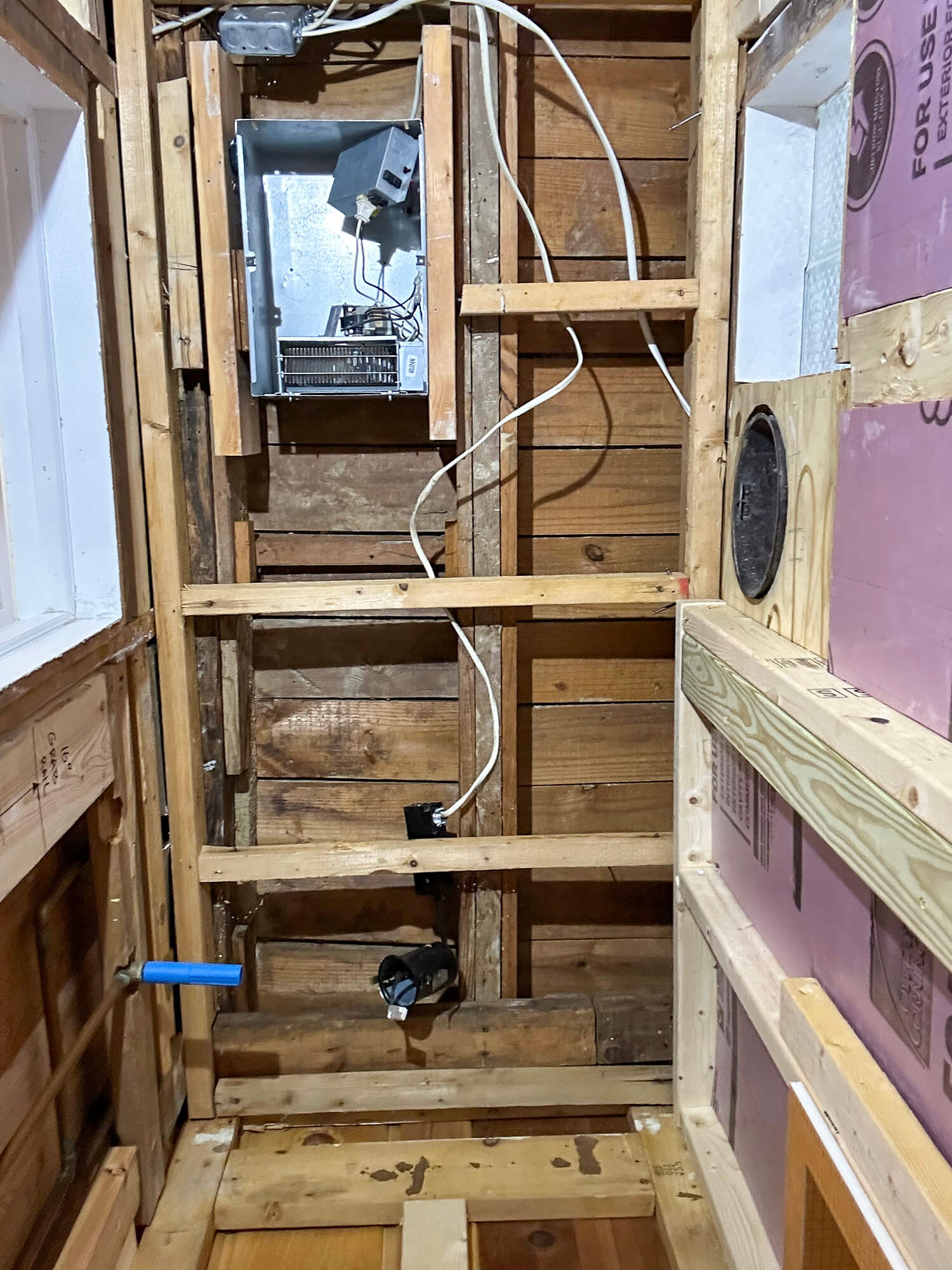 Old shower walls and floor removed with bare studs