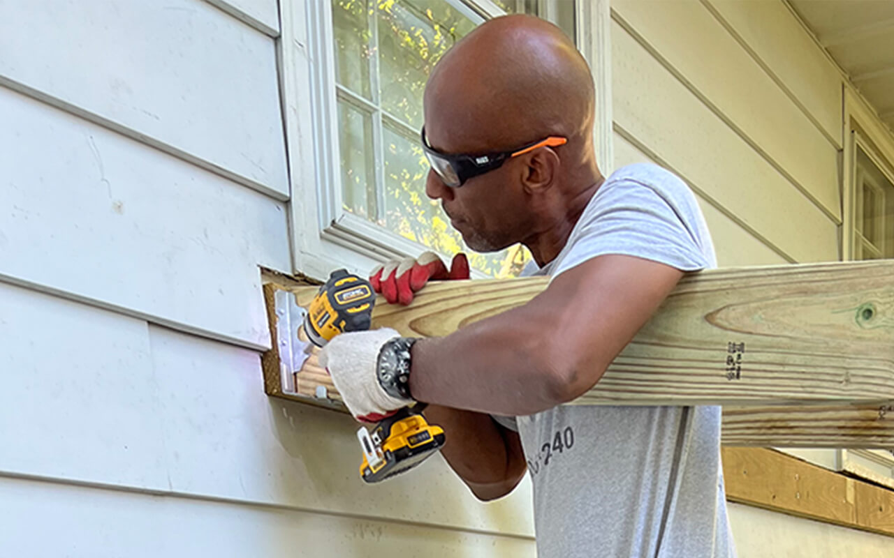 Sean Bruce screw driving wood to exterior wall