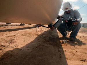 Inspector using a handheld scanner to examine underside of asset