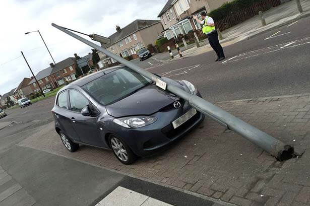 Lamp post fallen on car