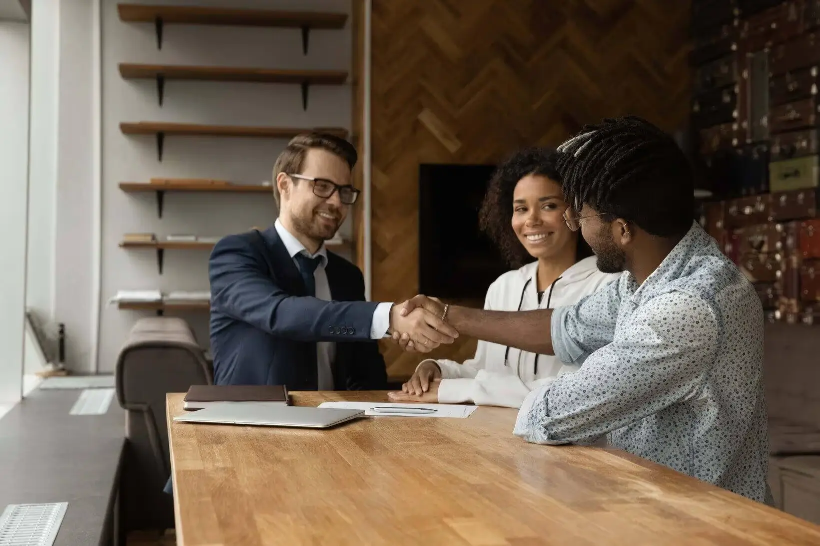 Couple meeting with financial advisor shaking hands at office – Endeavour Wealth financial planning Winnipeg