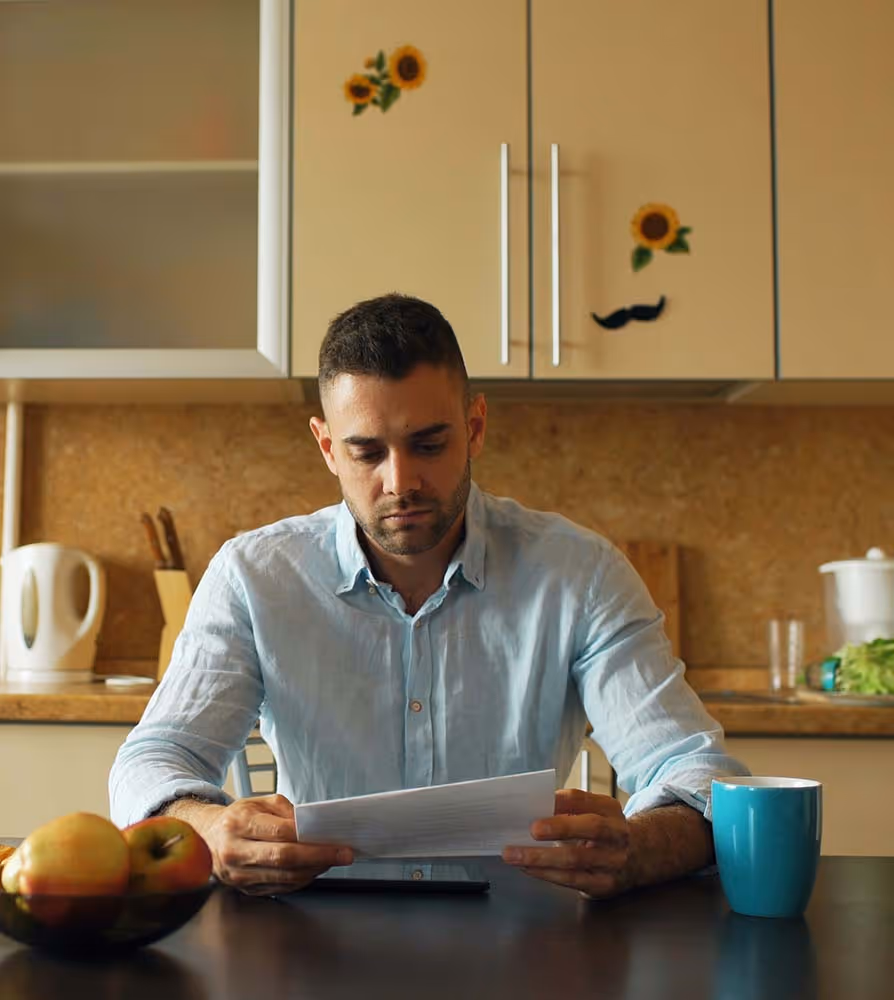 Man sitting at a table reading a paper– investment management and financial planning support in Canada