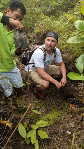 Man planting tree with guide – Endeavour Wealth community and sustainability commitment