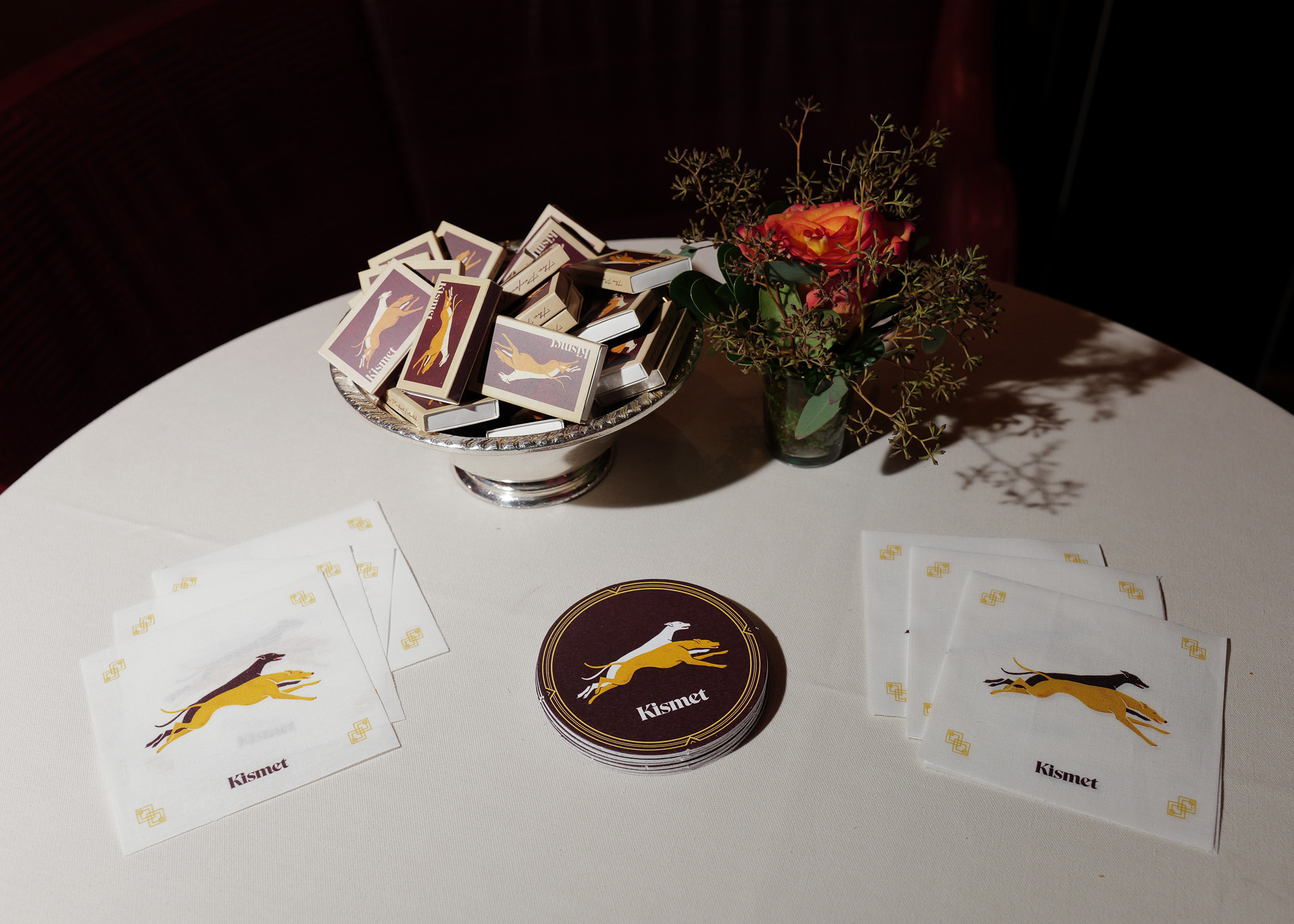 Kismet-branded coasters, napkins, and matchboxes celebrating the Fetch × Kismet partnership at the 2025 Fetch Pet Gala.