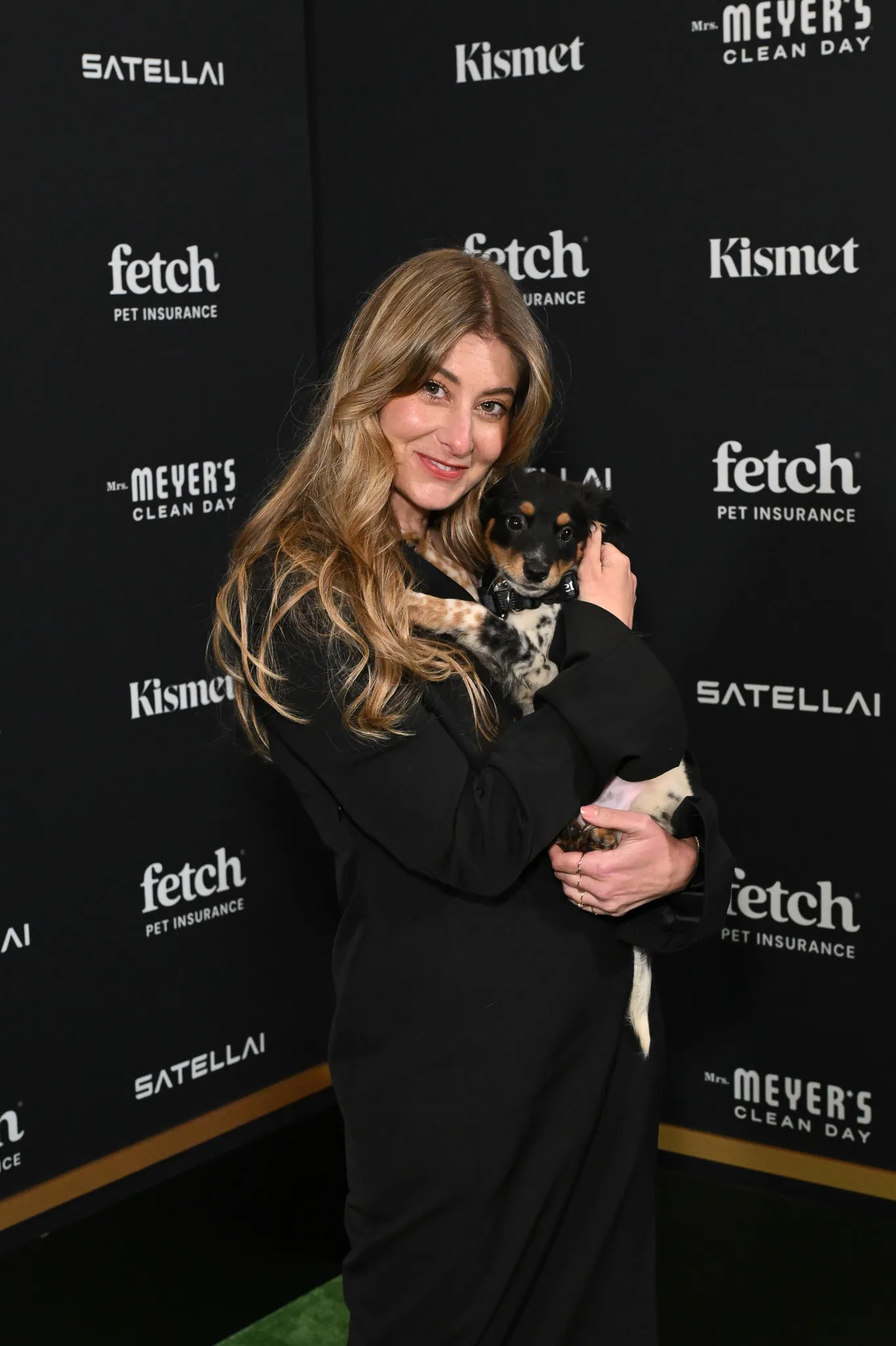 Guest poses with rescue pup from North Shore Animal League America at the 2025 Fetch Pet Gala.