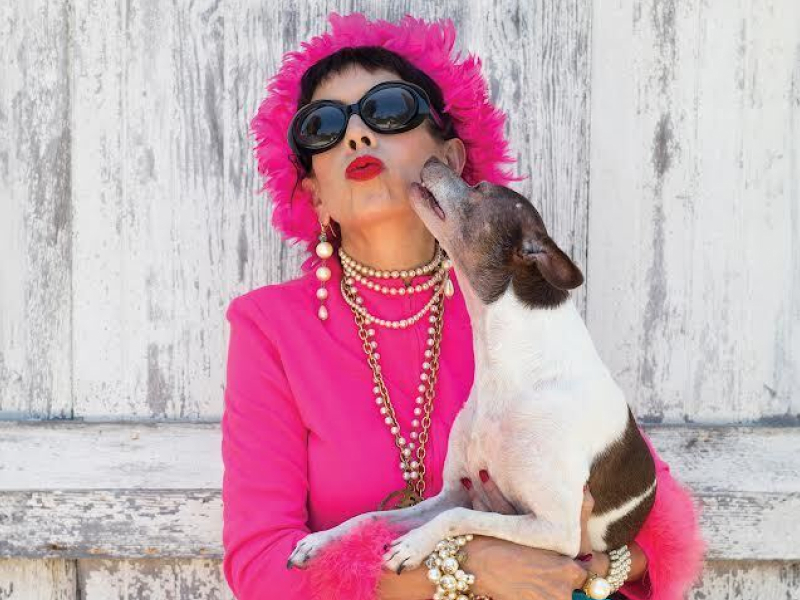 Dog kissing a woman in a pink outfit