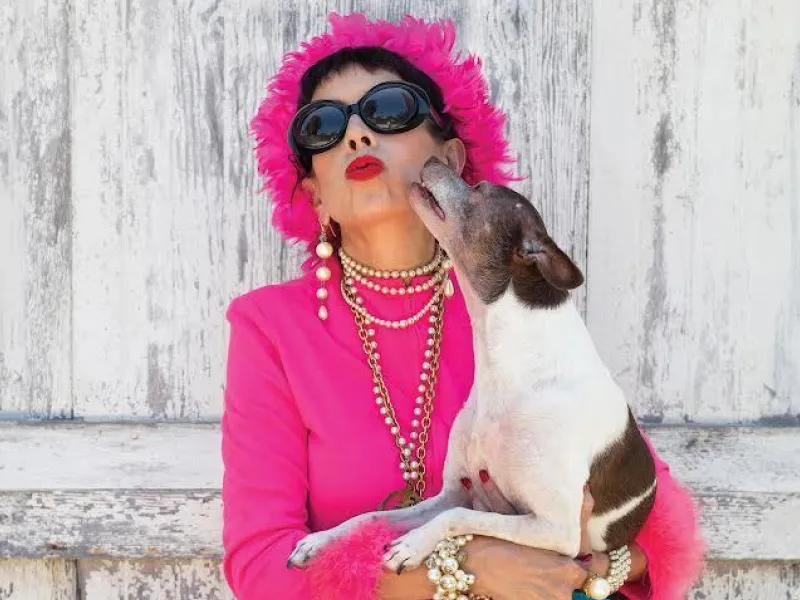 Dog kissing a woman in a pink outfit