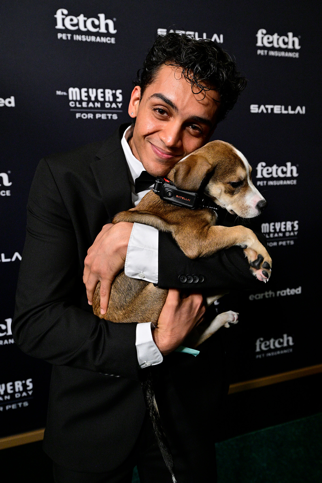 Guest poses on the green carpet with a pup from North Shore Animal League wearing a SATELLAI Go Collar at the 2026 Fetch Pet Gala.