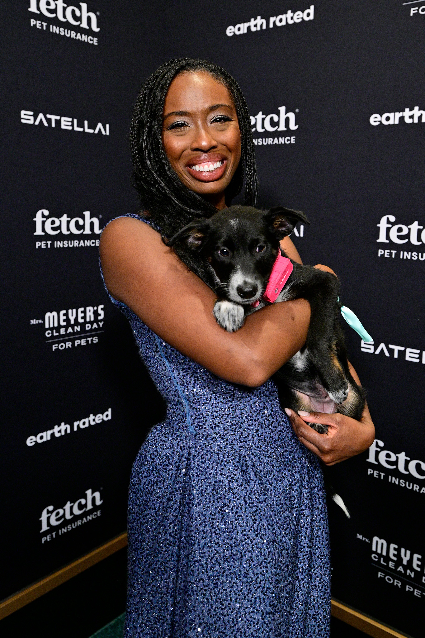 Guest poses on the green carpet with a pup from North Shore Animal League wearing a SATELLAI Go Collar at the 2026 Fetch Pet Gala.