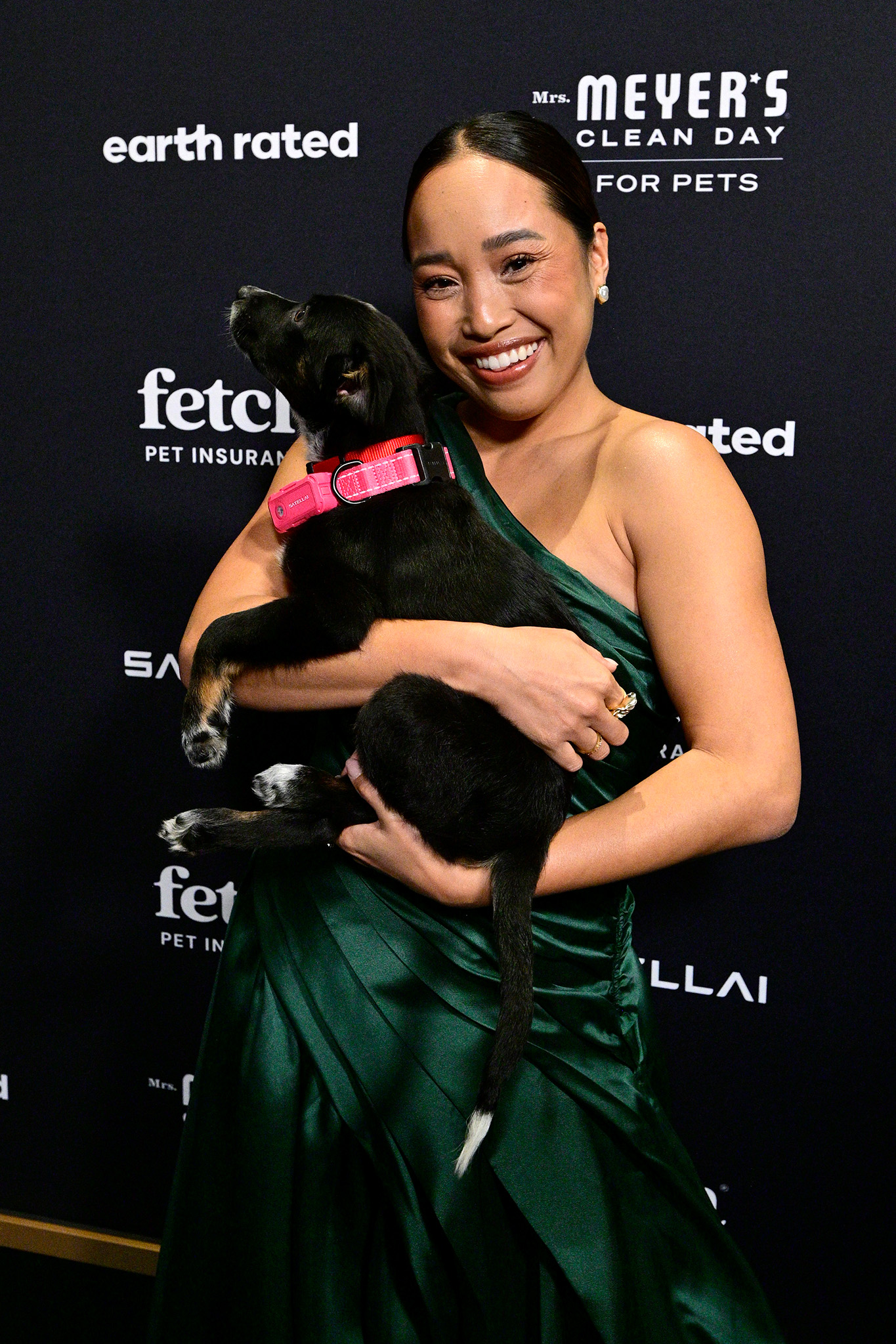 Guest poses on the green carpet with their pup at the Fetch Pet Gala in 2026.