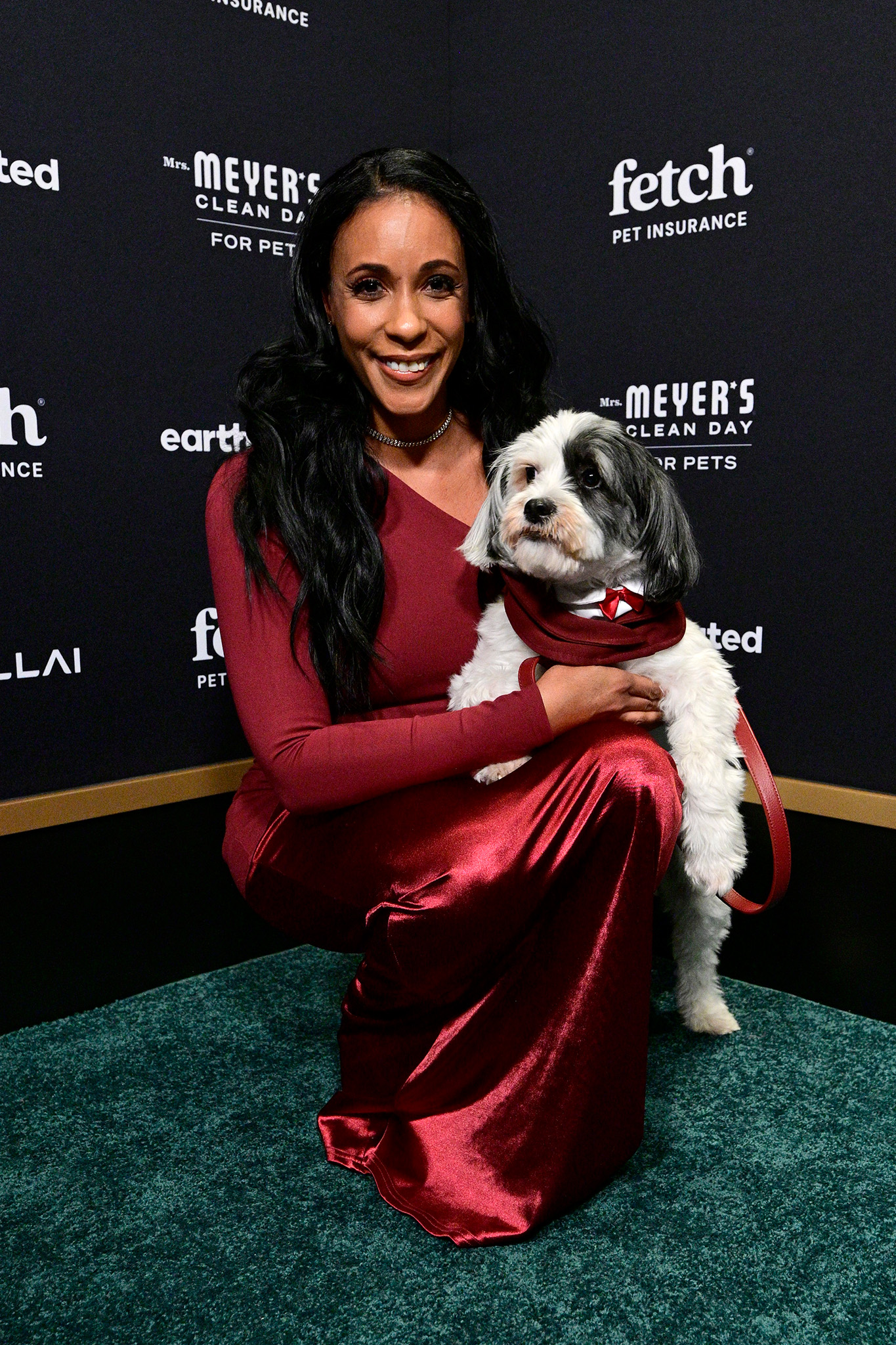 Guest poses on the green carpet with their pup at the 2026 Fetch Pet Gala.