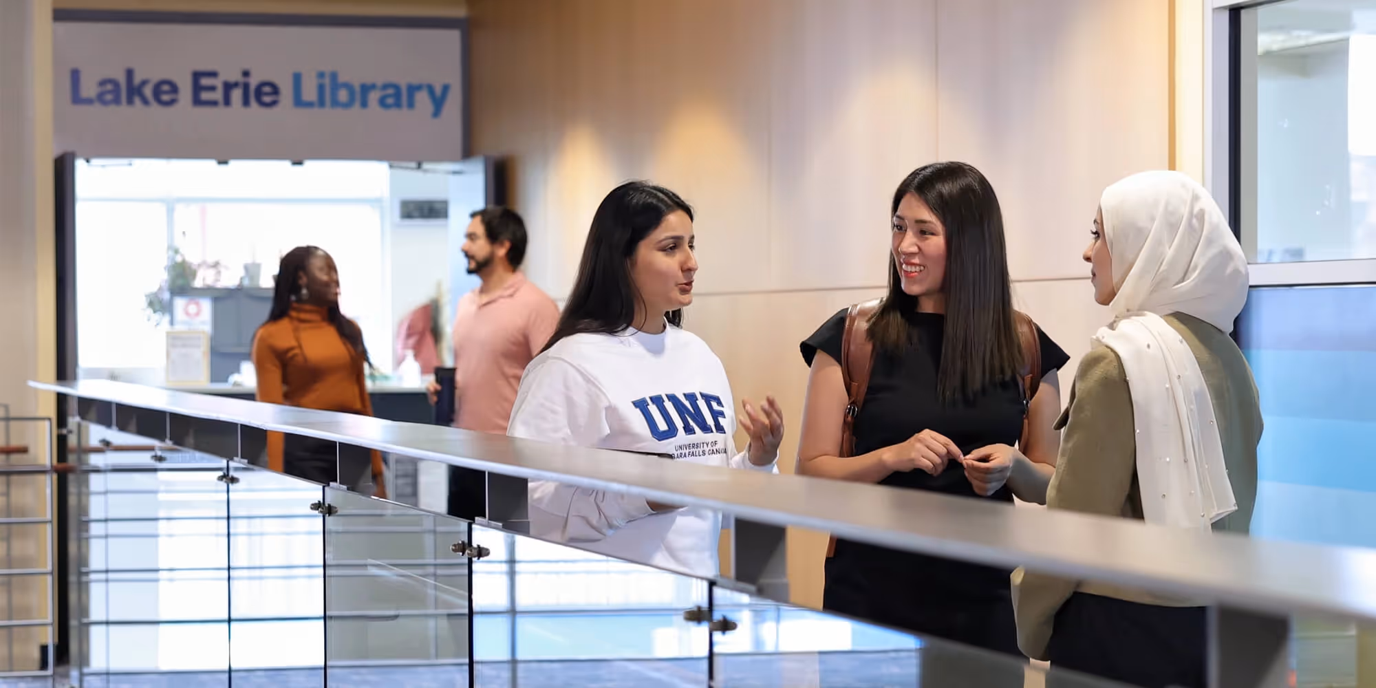 Estudiantes hablando al frente de la biblioteca de la Universidad de Niagara Falls en Canadá