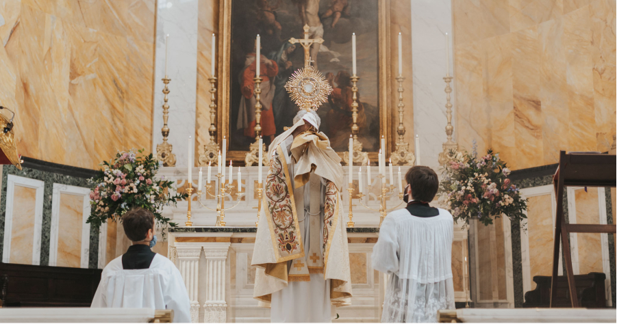 A priest holding the monstrance at the altar during Eucharistic Adoration