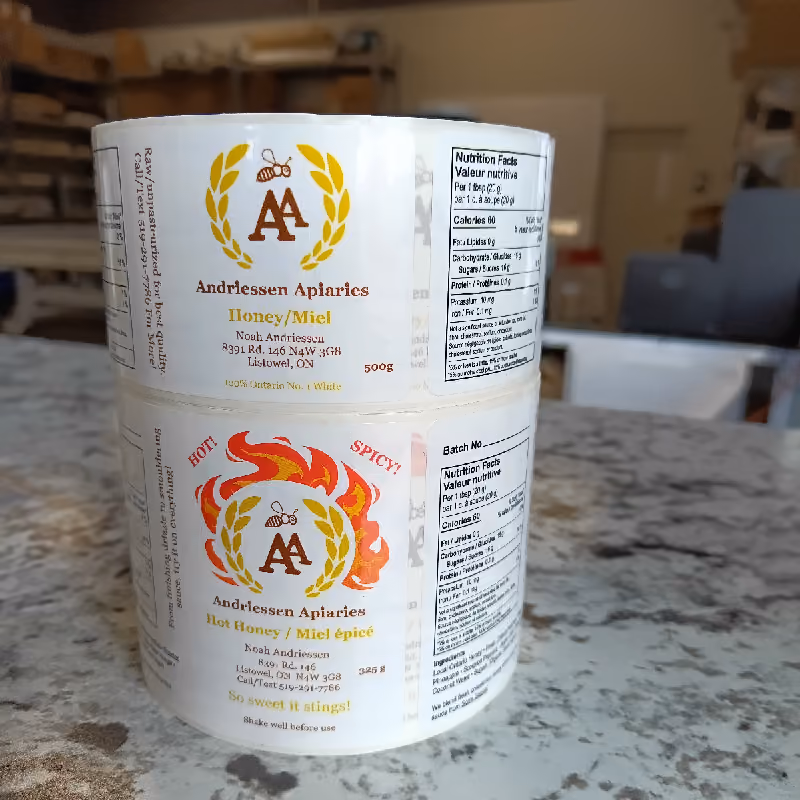 Photo of labels on a roll with Andriessen Apiaries branding, contact details, product description