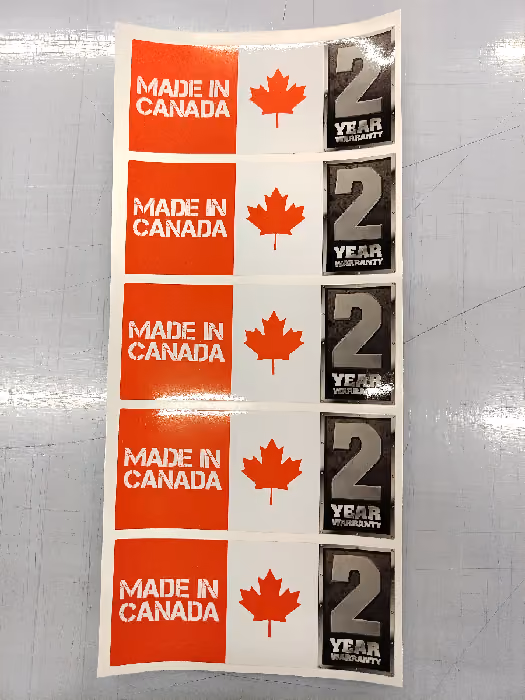 Photo of stickers on a sheet with "Made in Canada" on them, Canadian Maple Leaf and "Two Years Warranty"