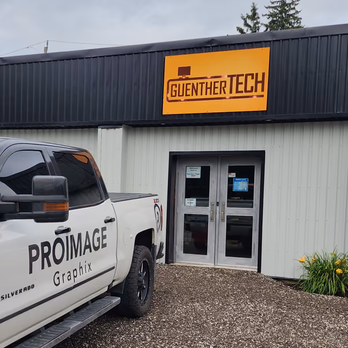 Photo of the outdoor store sign of Gunther TECH company and Proimage Graphix truck
